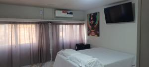 um quarto com uma cama e uma televisão de ecrã plano em AP CENTRAL VIP em Campina Grande