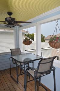 een patio tafel en stoelen op een veranda met een plafond bij Surf's Up! in Virginia Beach