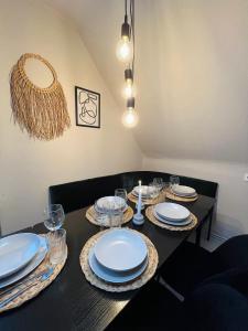 una mesa de comedor con platos y vasos. en OVERNIGHT Apartment No1 - Dachterrasse, Küche en Hannover