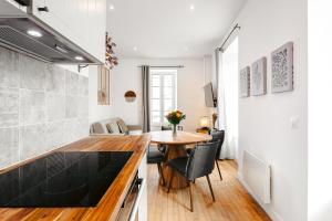 Una cocina y un comedor con mesa y sillas. en Cosy appart proche du marché, en La Rochelle