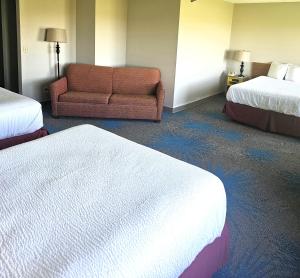 Habitación de hotel con 2 camas y sofá en Days Inn by Wyndham North Sioux City, en North Sioux City