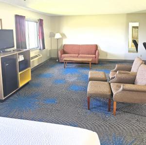 sala de estar con sofá, sillas y TV en Days Inn by Wyndham North Sioux City, en North Sioux City