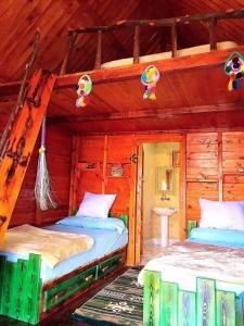 a bedroom with two beds in a log cabin at Marassina camp in Siwa