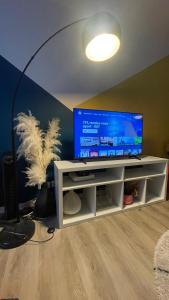 a living room with a tv on a white entertainment center at Paris Ouest Appartment in Courbevoie