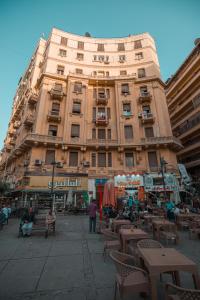 un gran edificio con mesas y sillas delante de él en Sama hotel en El Cairo
