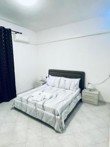 a white bedroom with a bed with white sheets and pillows at The Samantha Guest House in Santo Stefano di Magra
