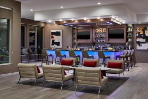 a restaurant with tables and chairs and a bar at AC Hotel by Marriott Tuscaloosa Downtown in Tuscaloosa