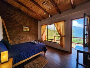 1 dormitorio con 1 cama azul y ventanas grandes en Hotel Pueblo del mundo, en Baños