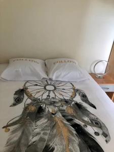 Una cama con un vestido y dos almohadas en Le Mirabeau - Deauville, en Deauville