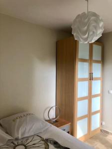 1 dormitorio con cama y lámpara de araña en Le Mirabeau - Deauville, en Deauville
