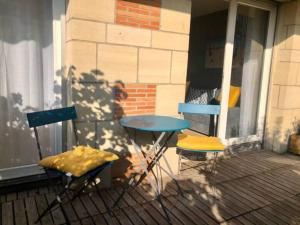 2 sillas y una mesa en un porche en Le Mirabeau - Deauville, en Deauville