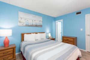 Dormitorio azul con cama y pared azul en Surfside I 304, en South Padre Island