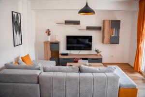 uma sala de estar com um sofá e uma televisão em Darki Apartments 4 - Very Central 100 Square Meters,Two Bedrooms,Free Parking em Ohrid