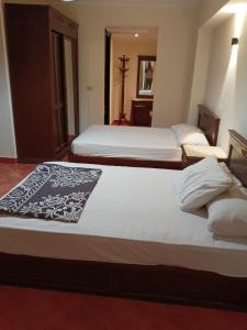 two beds in a hotel room with two bedsvisor at Porto marina in El Alamein +17 photos