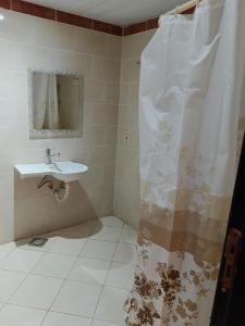 a bathroom with a sink and a shower curtain at Porto marina in El Alamein