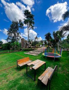 a park with three benches and a playground at Lara's Home Suites in Capitólio