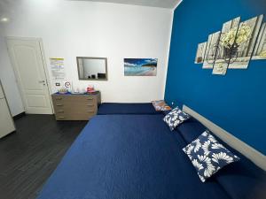 Affittacamere Sa Pardula في كالياري: غرفة نوم بجدران زرقاء وسرير مع الوسائد