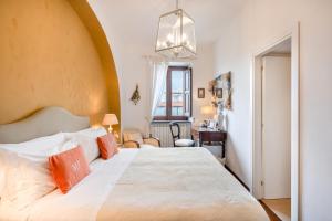 1 dormitorio con 1 cama blanca grande con almohadas de color naranja en Maison Fernanda, en SantʼAgata sui Due Golfi