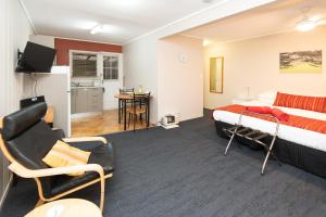 a hotel room with a bed and a kitchen at Cascade Garden Apartments in Burnt Pine