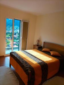 a bedroom with a bed and a large window at CASA Bela Vista in Machico