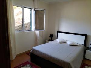 1 dormitorio con 1 cama y 2 ventanas en CASA Bela Vista, en Machico