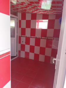 um quarto com um piso xadrez vermelho e branco em Tatil evi em Sheki