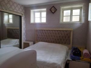 a bedroom with a bed and a mirror at Tatil evi in Sheki