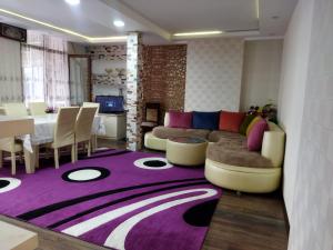 a living room with a couch and a purple rug at Tatil evi in Sheki