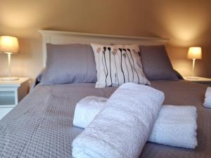 a bed with two pillows and towels on it at Entre Potes y Picos con WIFI y garaje in Turieno +26 photos