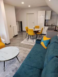 ein Wohnzimmer mit einem blauen Sofa und einem Tisch in der Unterkunft Apartment Sofia in Bihać