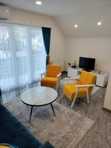 ein Wohnzimmer mit zwei Sesseln und einem Couchtisch in der Unterkunft Apartment Sofia in Bihać