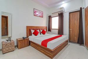 1 dormitorio con 1 cama grande con almohadas rojas en OYO Hotel Four S, en Haridwar