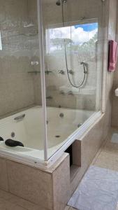 een badkamer met een bad en een douche bij casa de campo, dentro do urbano. in Piraquara