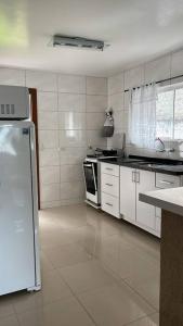 een keuken met witte kasten en een witte koelkast bij casa de campo, dentro do urbano. in Piraquara