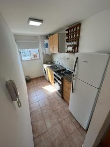 uma cozinha com um frigorífico branco e piso em azulejo em Departamento Ciudad Jardín em Billinghurst