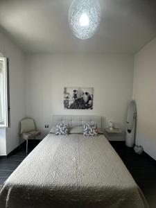 een slaapkamer met een groot bed en een kroonluchter bij Affittacamere Sa Pardula in Cagliari