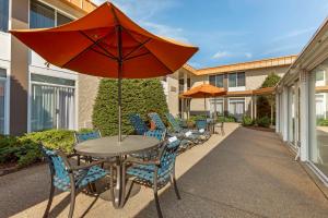 eine Terrasse mit einem Tisch und Stühlen mit einem Sonnenschirm in der Unterkunft Best Western Plus Coeur d'Alene Inn in Coeur d'Alene