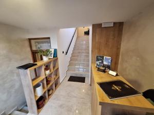 Apartmani Fantasia Cetinje في ستنيي: درج في غرفة مع مكتب وحقيبة درج