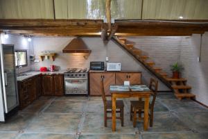 a kitchen with a table and a stove top oven at POSADA ROSSINA Habitaciones con baño privado y ambientes compartidos in San Rafael