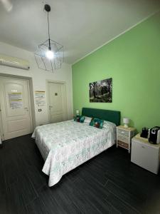 een slaapkamer met een bed en een groene muur bij Affittacamere Sa Pardula in Cagliari