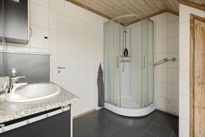 La salle de bains est pourvue d'une douche et d'un lavabo. dans l'établissement Leilighet i Nærbø sentrum, à Narbø