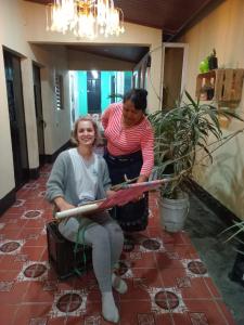 Deux femmes coupent un ruban dans une pièce dans l'établissement Hostal Sanjuanerita, à San Juan La Laguna