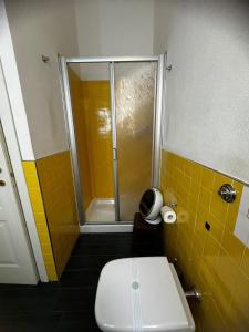 a bathroom with a toilet and a shower with yellow tiles at Affittacamere Sa Pardula in Cagliari