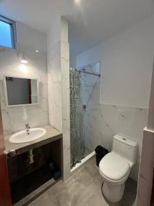 La salle de bains est pourvue de toilettes, d'un lavabo et d'une douche. dans l'établissement Arica Home, à Lurín