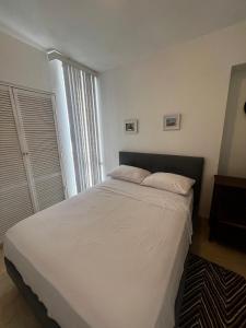 un letto in una camera da letto con una grande finestra di Apartamento céntrico en porlamar a Porlamar