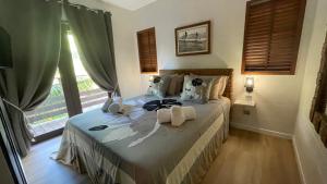 1 dormitorio con 1 cama con toallas en VILLA TAAROA LEGENDS, en Haapiti