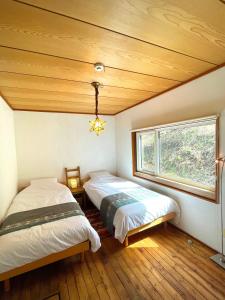 2 camas en una habitación con ventana en New Open!SHIZENTOYA Privete cottage for nature experience LakeView!, en Sobetsu