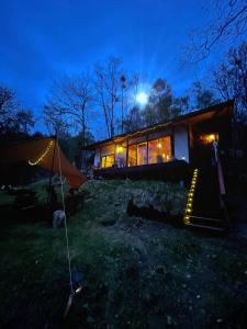 una casa con una tienda en el patio por la noche en New Open!SHIZENTOYA Privete cottage for nature experience LakeView!, en Sobetsu