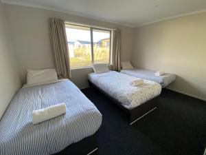 two beds in a room with a window at Southholm in Lake Tekapo
