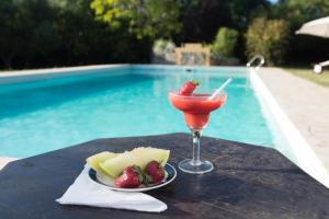 una bebida y fruta en una mesa junto a la piscina en Las Nubes Apart en Merlo